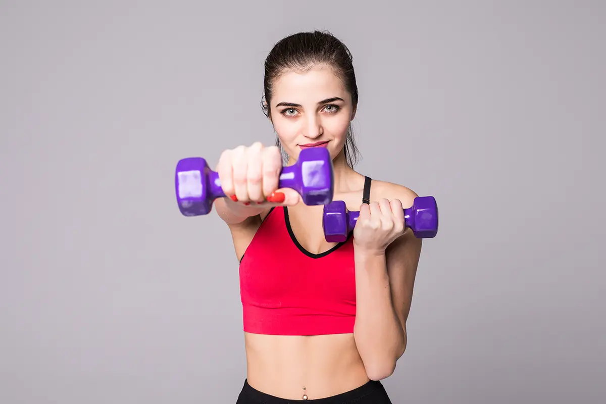 Woman lifting dumbbells during fat loss workout to burn calories and boost metabolism