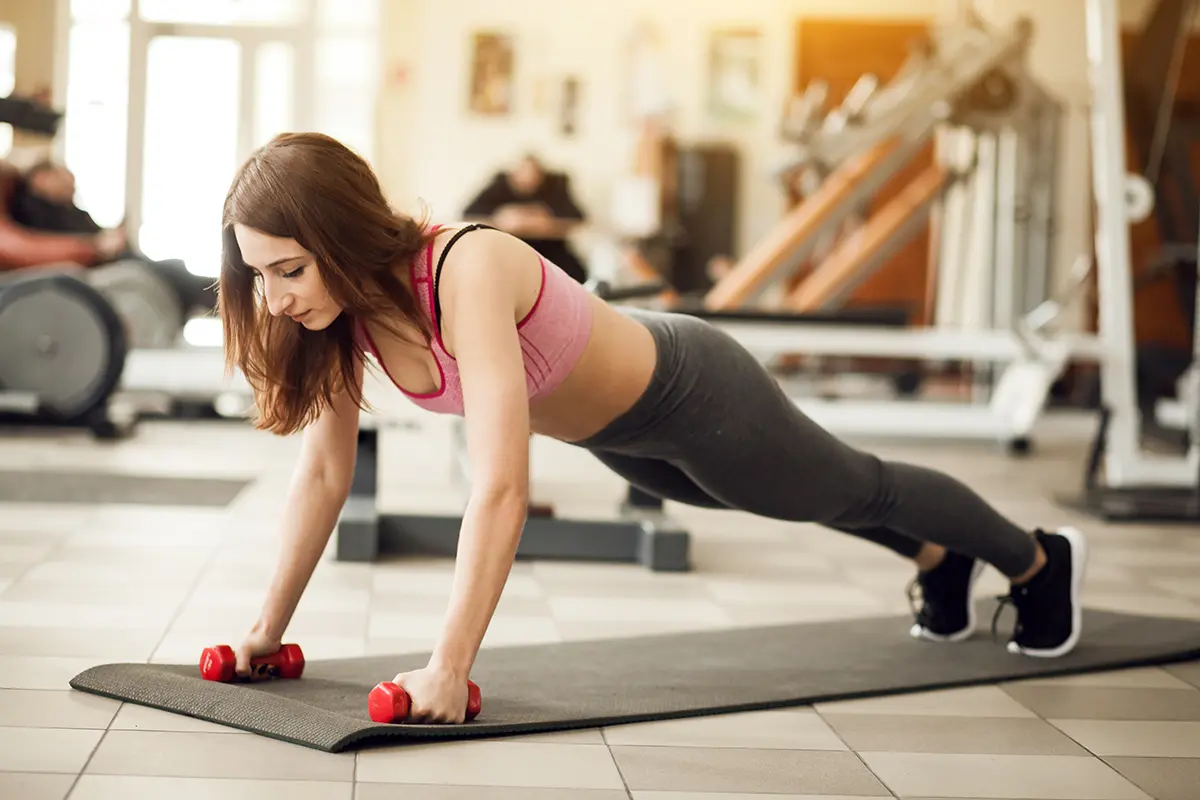 woman strength training with dumbbells for female to building muscle tone boosting metabolism 